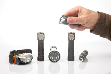 Selection of different flashlight types displayed on a white background for outdoor enthusiasts © photosaint