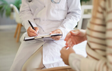 Doctor writing in clipboard close up, female patient consulting woman gynaecologists, endocrinologists, private GP specializing in female care health, contraception, family planning in clinic © Studio Romantic