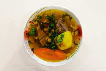 Traditional Asian soup Chorba or shurpo with beef, potato, carrot and chickpea.