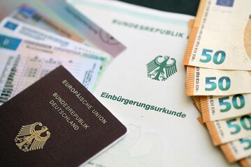 German passport and an identity card on an official naturalization certificate. Symbolic for successful acquisition of German citizenship close up