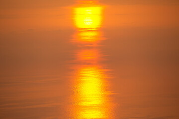 Sunset over calm water reflects golden hues during peaceful evening hours
