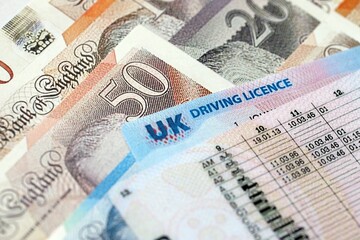 United Kingdom driving license card on UK British pounds money close up