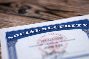 Obraz premium Social security number card on brown wooden background surface close up