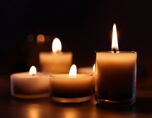 close up of scented candles burning in the dark cinematic lighting with deep shadows moody atmosphere