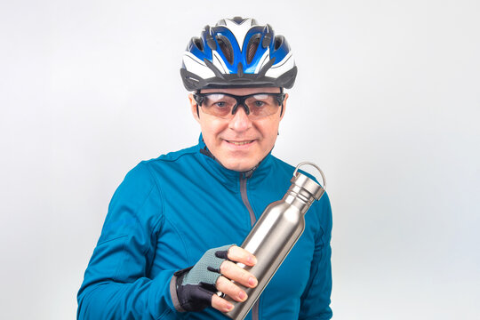Cyclist in blue attire holds a stainless steel water bottle ready for riding adventure