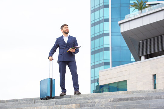 Business man preparing for travel in a modern urban environment with suitcase