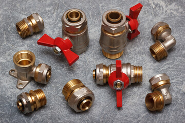 The set of valves and fittings for water or gas plumbing. Closeup view with gray concrete background.