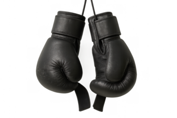 Black boxing gloves hanging, representing strength, combat sport, boxing, and martial arts training equipment