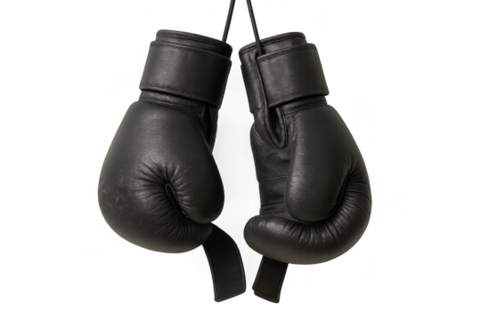Black boxing gloves hanging, representing strength, combat sport, boxing, and martial arts training equipment