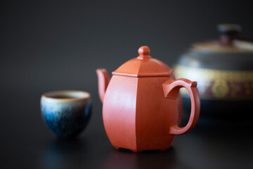 Antique purple clay teapot and teacup with tea leaves
