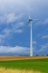 Obraz premium Wind turbine generating clean energy on a field in Saron sur Aube