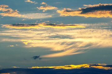 Beautiful sunset sky with clouds glowing in shades of orange and gold over the horizon