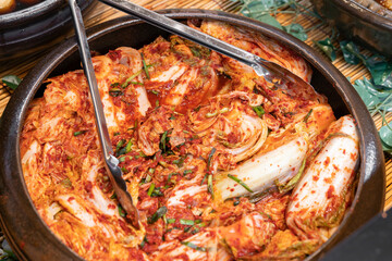 Traditional Korean Napa cabbage kimchi made with chili pepper flakes, garlic, ginger, and fish sauce, fermented to develop a rich spicy and tangy flavor, served as a classic Korean side dish.