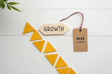 Flat lay of yellow paper triangles ascending towards Growth