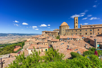 Naklejka premium Volterra cityscape with medieval buildings under blue sky