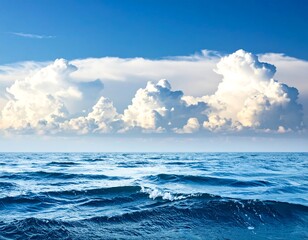 Fototapeta premium Open water blue ocean with small waves stretches to meet fluffy white cumulus clouds under a bright blue sky