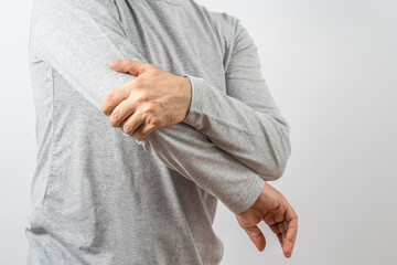 Arthritis symptoms, suffering from pain. The hands of the senior man massage a painful elbow. Inflamed male joint, stiffness of movement. Old age, health. Close up view..