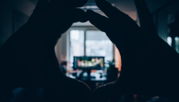 First-person POV shot from inside cupped hands during eye palming, showing slivers of an office.