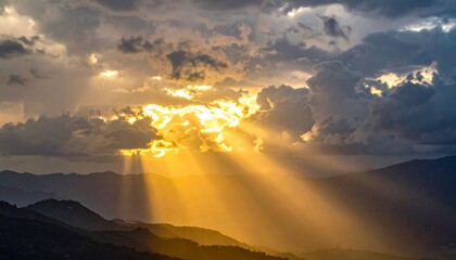 Majestic sunset captures sun rays bursting through dramatic cloud formations, illuminating distant mountains and creating a breathtaking scene