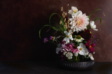 Flower arrangement with Dahlias with dark background. 