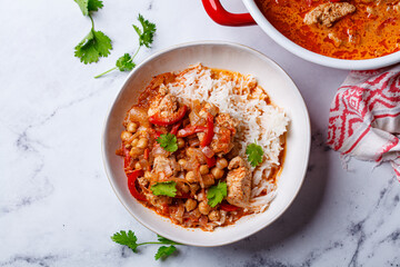Tikka masala with chicken, chickpeas and rice in bowl.