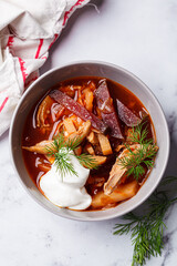 Classic homemade borscht with chicken in a grey bowl.