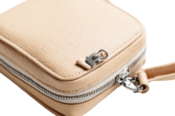 Close-up detail of a small, tan leather bag, zipper, and stitching, isolated on black