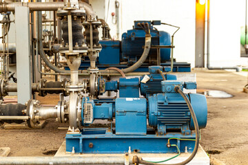 Industrial pumps and metal pipes in a machinery equipment, blue industrial motors.