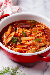 Classic borscht with chicken in a red pot.