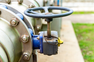 Industrial pipeline valve wheel with bolts and flanges controlling flow system