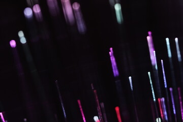 A vivid, abstract close-up of brilliant magenta and purple fiber optic strands glowing on a pitch-black background.