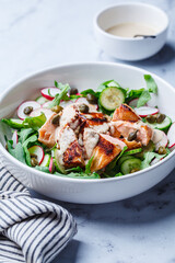 Salad with grilled salmon, cucumber, radish, capers and tahini dressing.