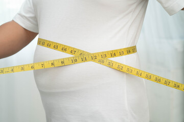 Asian woman with fat belly big size overweight and obesity with measure tape.