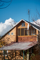 Rustic Dacha House Gable with Ornate Security Bars in Autumn Foliage
