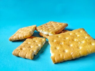 golden colored broken biscuits on bright blue background