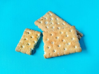 golden colored broken biscuits on bright blue background