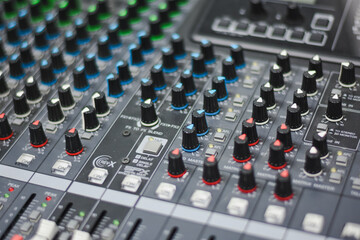 Obraz premium Close-up view of faders and knobs on an audio mixer.