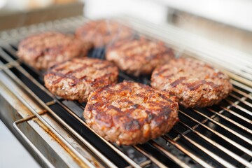 Grilled beef burgers sizzling on a barbecue grill, perfect for summer cookouts