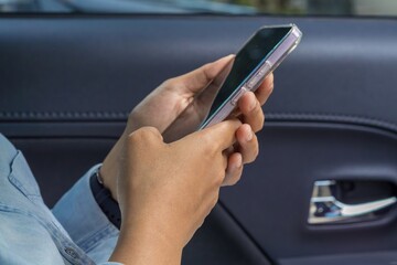 Close up of female hands holding a smartphone in car