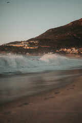 Sunset Wave at Camps Bay Beach with View of Maiden’s Cove.