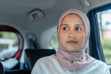 A young Asian Muslim woman in a car. Traveling by car.