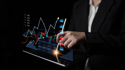 Business professional engages with digital financial data on a tablet, showcasing graphs and trends...