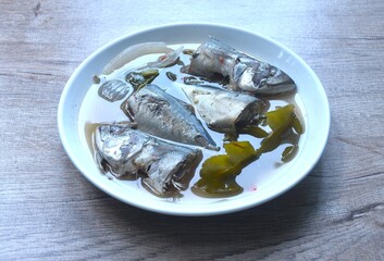 spicy boiled mackerel with chili and ginger in tom yum soup on plate