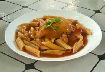 baking penne pasta topping slice chicken in sweet and sour gravy sauce on plate    