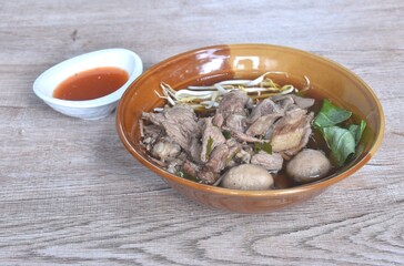 boiled braised pork meatball and tendon couple organ in herb brown soup on bowl dipping spicy chili sauce 