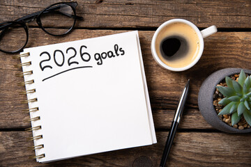 New year goals 2026 on desk. 2026 resolutions list with notebook, plant on wooden background. Resolutions, plan, goals, action, checklist, idea concept. New Year 2026 resolutions, copy space