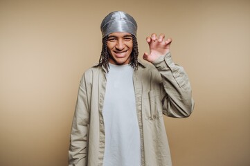 Smiling person wearing a durag and casual clothing, posing playfully.