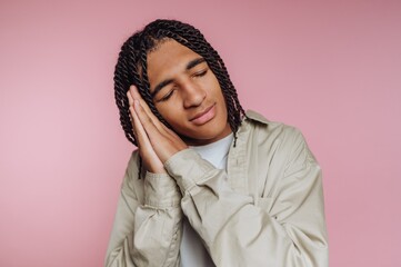 Young Man Mimicking Sleep on Pink Background
