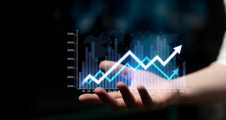 A hand presents a digital graph that shows an upward trend against a faint world map background,...