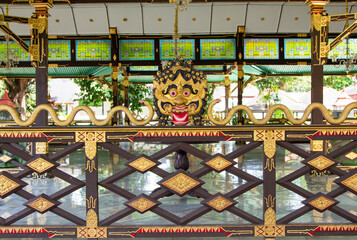 Traditional Javanese mask sculpture with gold and red details, representing cultural heritage and...